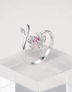 Gedetailleerd aanzicht van een 925 zilveren kersenbloesem ring met een roze steen.