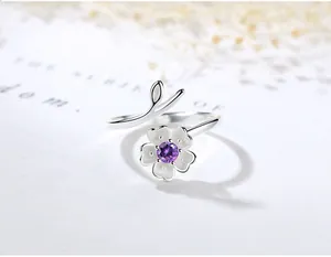 Primo piano di anello aperto a fiore di ciliegio in argento 925 con pietra viola.