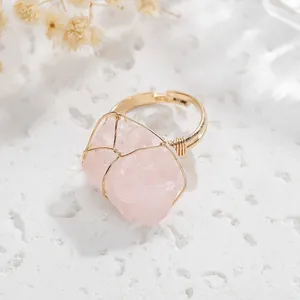 Detailed view of handmade gold wire wrapped ring with irregular pink raw stone