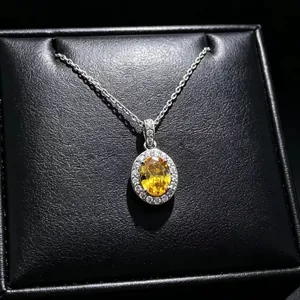 Detailed close-up of a yellow oval moissanite pendant necklace in a black box.
