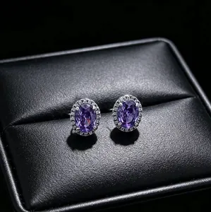 Detailed view of elegant purple oval halo stud earrings on black textured jewelry box