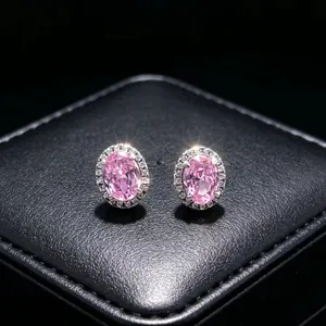 Detail of elegant pink oval moissanite stud earrings with a halo of clear stones