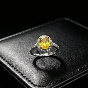 Detail of elegant silver ring with yellow oval gemstone and sparkling diamond halo