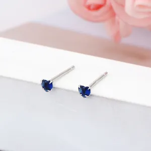 Gros plan de boucles d'oreilles cœur en argent 925 avec saphir bleu de 3 mm de diamètre