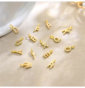 Detailed shot of gold-plated S925 silver alphabet pendants featuring pave-set stones