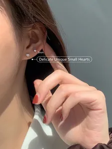 Gros plan d'une petite puce d'oreille cœur en argent S925 de 3mm sur un modèle