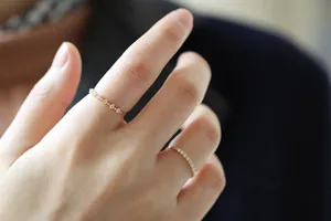 Macro dettaglio di un anello in argento placcato oro 14K con zirconi indossato