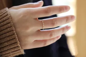 Dettaglio di un delicato anello in argento s925 placcato oro con piccoli zirconi brillanti