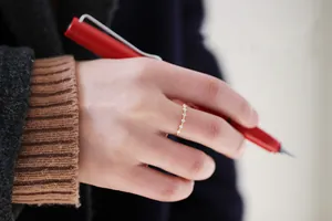 Primo piano di un anello minimalista in argento placcato oro con pietre di zircone
