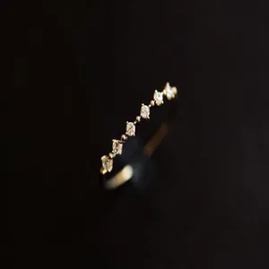 Primo piano di un anello sottile in argento placcato oro 14K con sette pietre di zircone