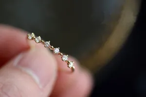 Primo piano di un elegante anello sottile in argento S925 con piccoli zirconi placcato oro