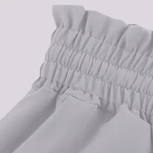 Close-up of the elastic paper bag waistband on high-waisted wide-leg trousers for women