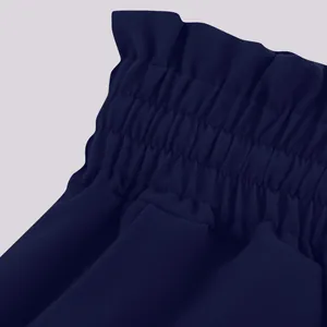 Close-up detail of high-waisted elastic paperbag waistband on navy blue wide-leg pants