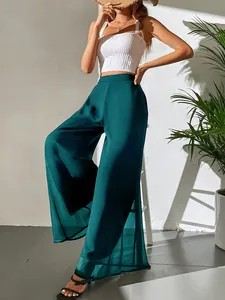 Détail du pantalon large en mousseline vert foncé fluide pour un look de vacances