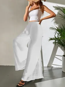 Vue complète du pantalon large en mousseline blanche sur mannequin en studio ensoleillé