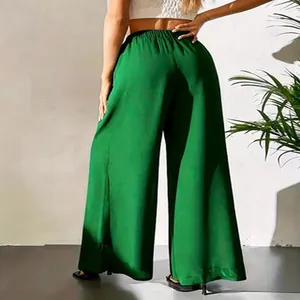 Vue détaillée du pantalon large en mousseline verte de dos, montrant la texture fluide