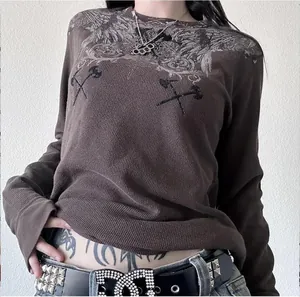 Vista detallada de camiseta marrón de manga larga con estampados de alas y bordados vintage