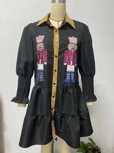 Detailed view of festive nutcracker sequin embroidery on black tiered Christmas dress