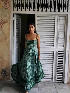Elegant green checkered spaghetti strap maxi dress with ruffled hem in a vintage setting