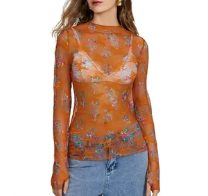 Close-up detail of women's orange sheer floral lace long sleeve mesh top shirt