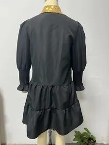 Detailed back view of a black long-sleeved Christmas dress with a gold sequined collar.