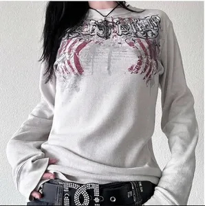 Detalle de camiseta blanca de manga larga con punto gofre y gráfico de alas