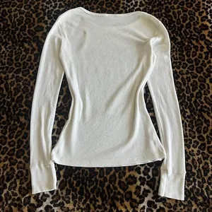 Primer plano del tejido de punto acanalado blanco en una camiseta ajustada de mujer