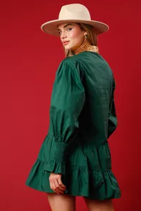 Rear view of a dark green long-sleeve Christmas dress with a sparkling gold sequin collar.