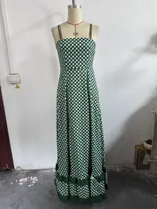 Detail of green and white checkered maxi dress with ruffled hem and slim fit