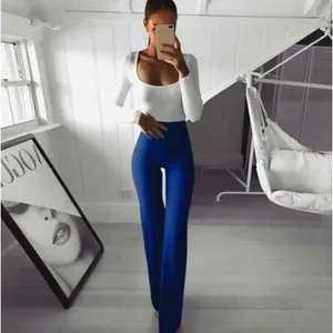 Modelo con pantalones de yoga acampanados azules de cintura alta y body blanco largo