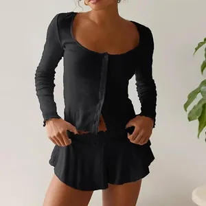 Close-up of black ribbed fabric details with lettuce edge trim and button-up front