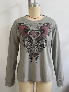 Detalle del estampado de alas retro en camiseta gris de punto gofrado.