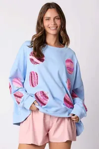 Détail du sweat-shirt de Noël bleu clair avec broderie de boules en sequins roses