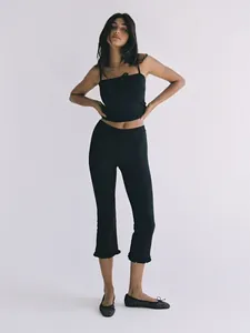 Stylish black high-waisted cropped leggings featuring a feminine ruffle hem design