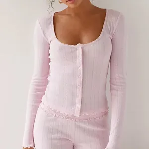 Detail view of pink ribbed cardigan with delicate lettuce trim and button front.