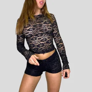 Detailed view of women's sexy black sheer lace long sleeve top with intricate floral patterns