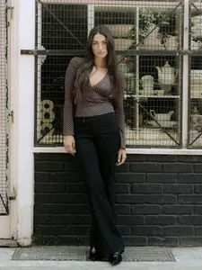 Elegante top de lunares con cuello en V profundo y manga larga para un look esbelto