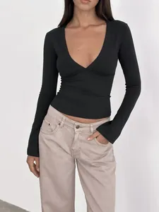 Primer plano de un elegante top negro de manga larga con cuello en V profundo para mujer joven