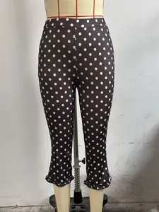 Detailed view of stylish black polka dot cropped pants with feminine ruffled hem design