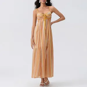 Détail d'une robe maxi à rayures avec fines bretelles et nœud décoratif sur le devant