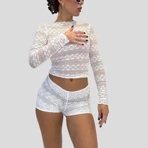 Close-up of white sheer lace long-sleeve crop top and matching shorts on model