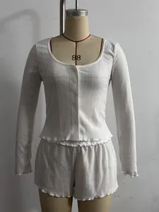 Close-up detail of white French style ribbed cardigan and shorts set with lettuce trim