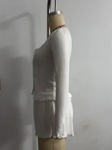 Side view detail of white knit two-piece set with ruffled lettuce edges on mannequin
