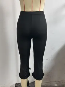 Detailed rear view of black cropped casual pants featuring stylish ruffled hem on a mannequin