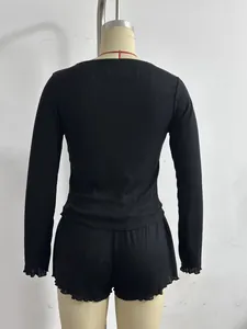 Elegant back view of black ribbed knit two-piece lounge set with lettuce trim.