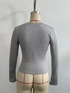 Vista trasera de un top gris de manga larga y corte entallado para mujer en maniquí.