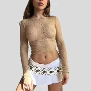 Detailed view showing the intricate sheer floral lace texture of the tan crop top