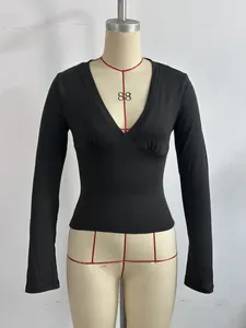 Vista frontal de una blusa negra de manga larga con escote en V profundo en un busto de maniquí