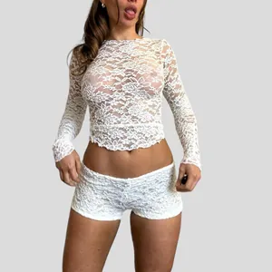 Close-up detail of sheer white floral lace fabric on long sleeve slim fit cropped top for women