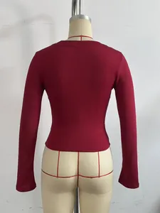 Vista posterior detallada de un top burdeos de manga larga ajustado en un maniquí